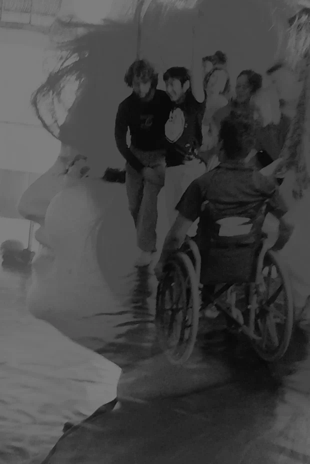 Double-exposed black-and-white photograph blending a close side profile of a woman with a scene inside a dance studio. In the overlaid studio image, several dancers—including a wheelchair dancer—rehearse across a wide marley floor. The two scenes merge so the dancers appear to be moving inside her head, suggesting that her mind is filled with dance, disability culture, and the possibilities of access.